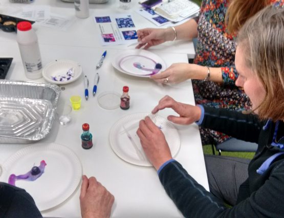 A group of people engaging in craft activities around a table.